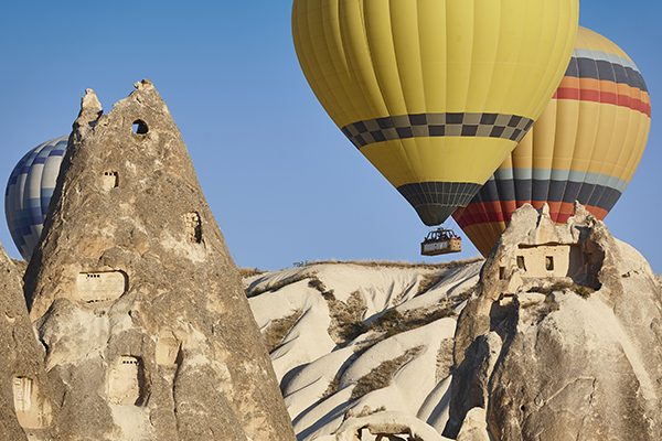 Hot air balloons rising over Cappadocia at sunrise