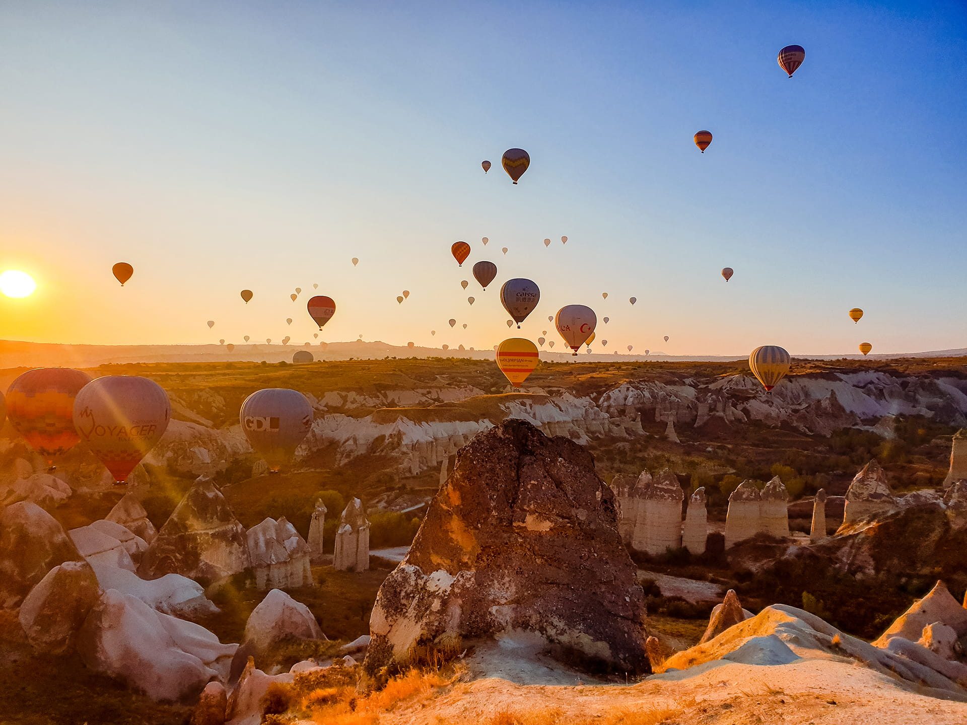 Hot air balloons rising over Cappadocia's fairy chimneys at sunrise